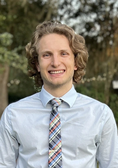 headshot of me wearing a green button-up shirt