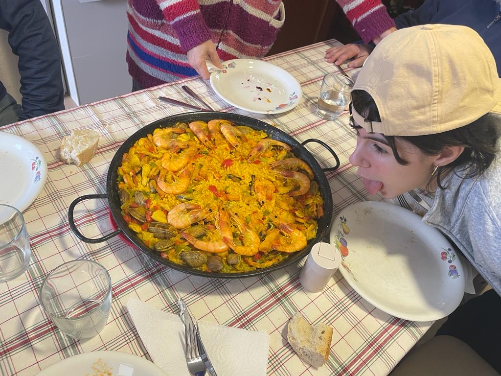 Ana posing for a funny picture in front of our paella dinner